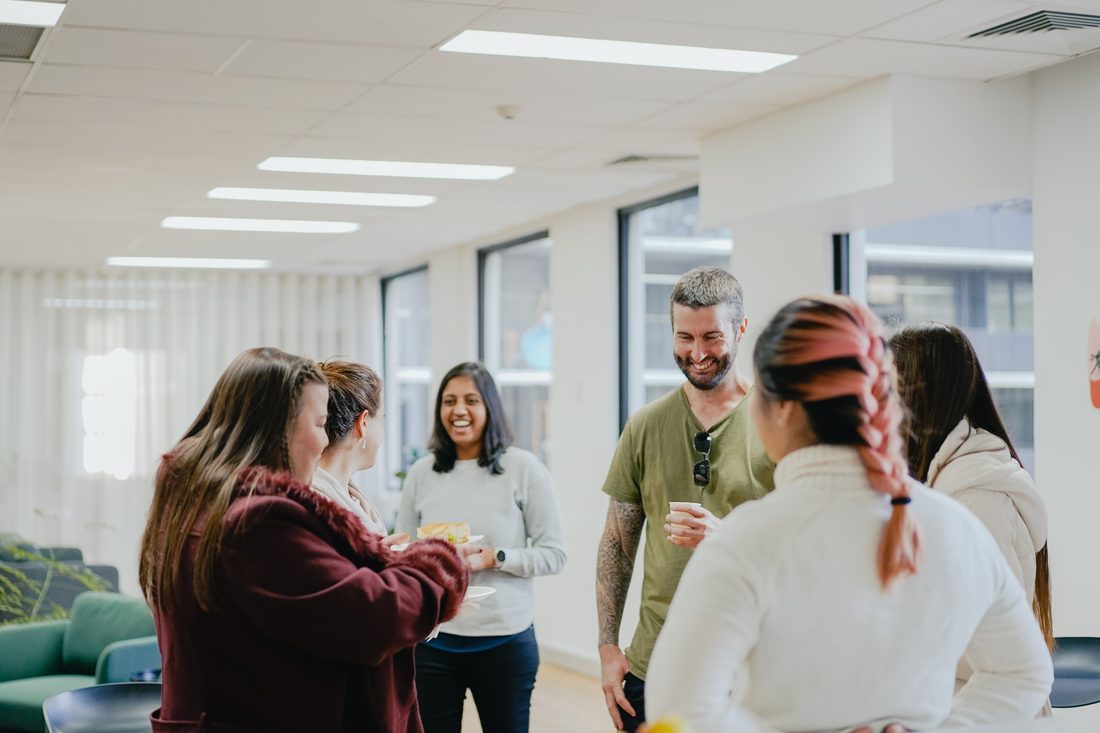 A team gathered and talking in an office